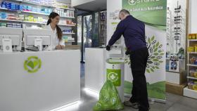 Recogida de medicamentos depositados en el punto Sigre de una farmacia.