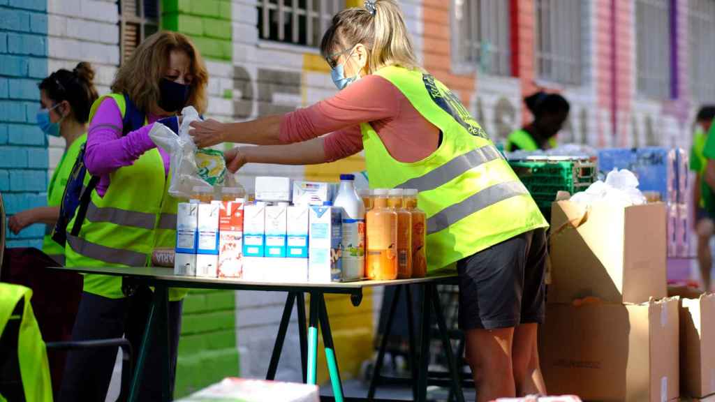 Voluntarias preparan y reparten comida en el madrileño barrio de Aluche.