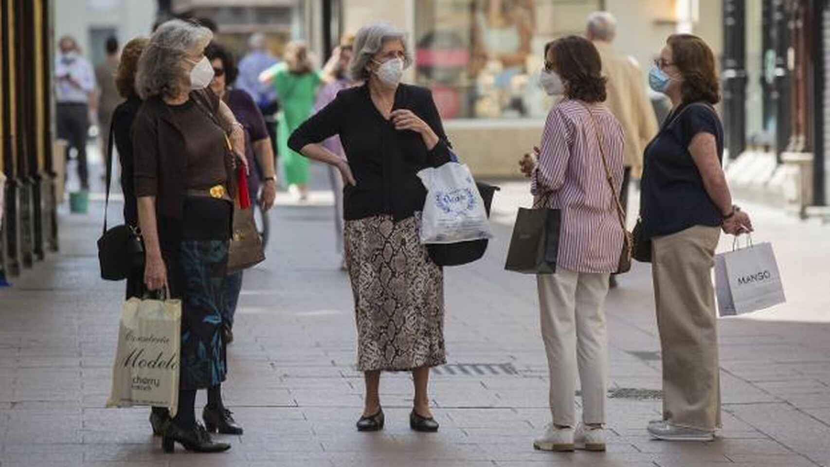 Un grupo de mujeres conversa en una calle de Sevilla con las mascarillas puestas. EFE