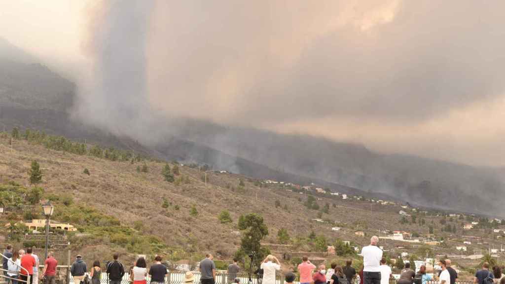 Varias personas observan la evolución del volcán de la isla de La Palma desde la localidad de Tajuya, en el municipio de El Paso.