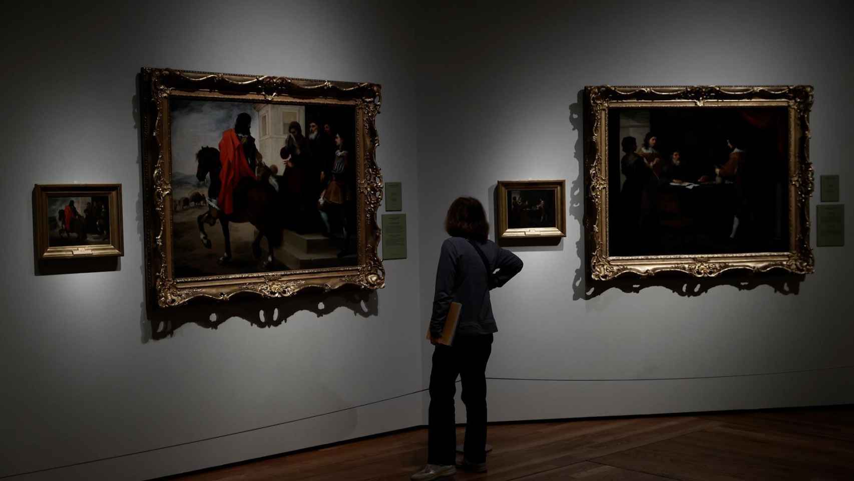 Una mujer observa los cuadros de Murillo 'La despedida del hijo pródigo' y 'El hijo pródigo recoge su legítima' durante la presentación de la exposición.