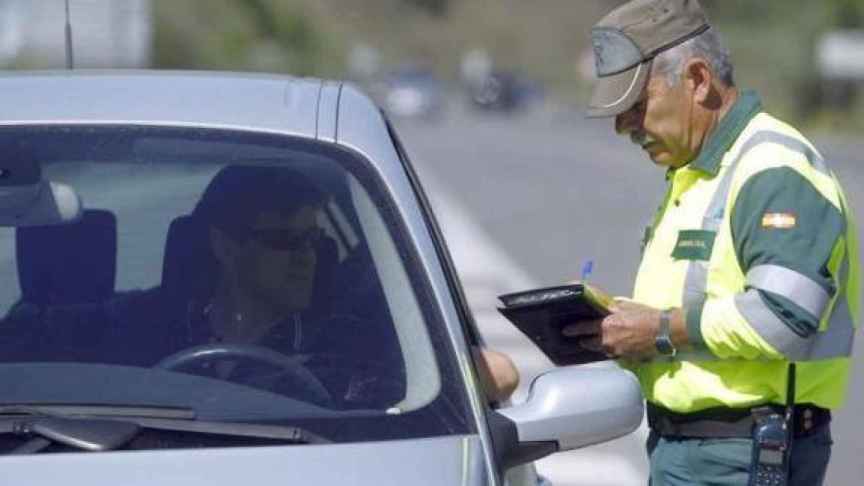 Un guardia civil multa a un conductor.