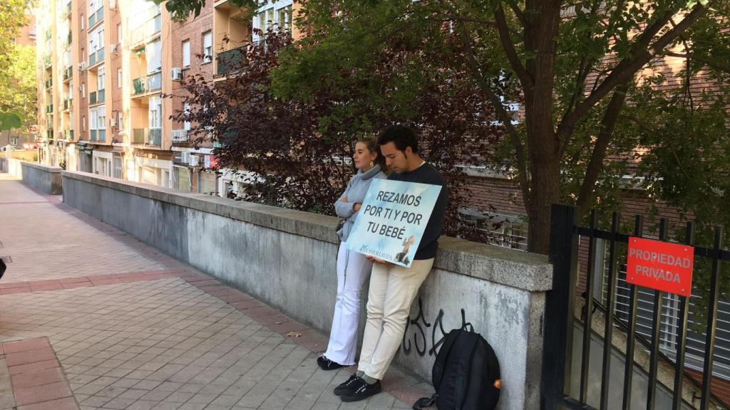 Two young people hold a sign in front of the Dator clinic in Madrid.