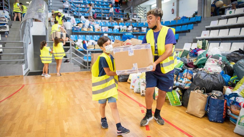 Noah and Fabián help with the donations that arrive at the pavilion.