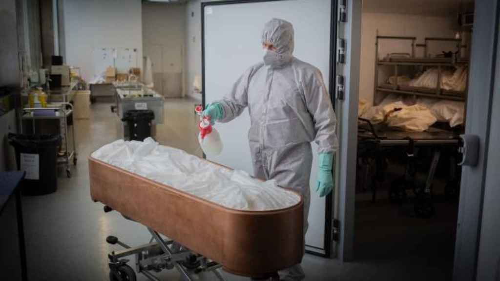 Un operario de una funeraria desinfecta un ataúd en plena pandemia