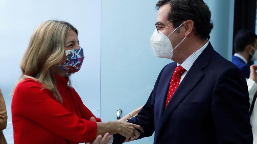 Yolanda Díaz, saluda con las dos manos al presidente de la CEOE, Antonio Garamendi.