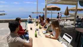 Varias personas beben en un bar de Málaga capital.