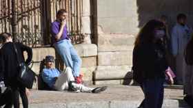 Estudiantes toman el sol en una calle de Salamanca