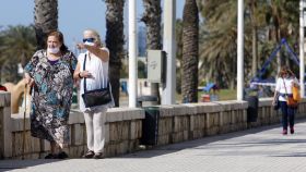 Dos mujeres caminan por el paseo marítimo Pablo Ruiz Picasso.