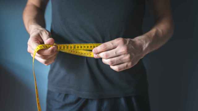 Una persona mide el contorno de su barriga.