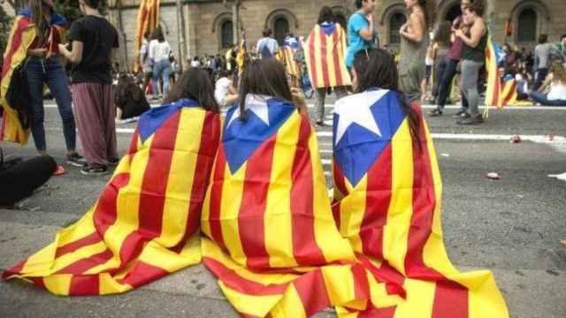 Tres chavales con esteladas en la espalda durante una manifestación de la Diada de Cataluña.
