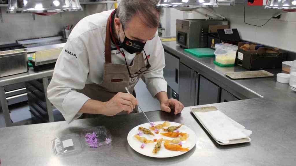 El chef Iñaki Rodaballo decora con flores de ajo su ración de patatas 'candy crunch brava'.