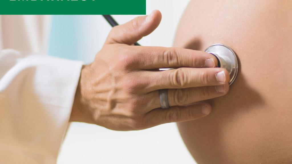 Una mujer embarazada es auscultada por un médico