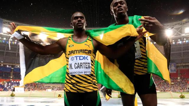 Nesta Carter y Usain Bolt con la bandera de Jamaica tras una competición