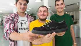 De izquierda a derecha: Aitor Carratalá, Diego Soliveres y Roberto Mohedano, cofundadores de Timpers, muestran una de sus zapatillas con el nombre de la marca bordado en Braille.