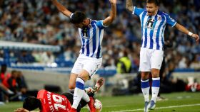 Los jugadores de la Real Sociedad pelean un balón con un rival del Mallorca en el suelo