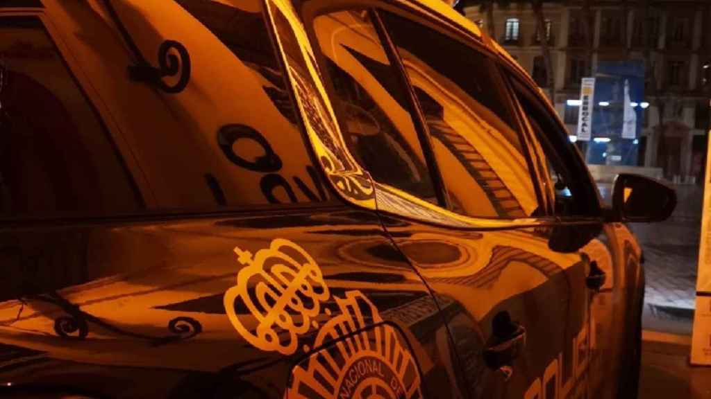 Foto de un coche de la Policía Nacional patrullando de noche en Málaga