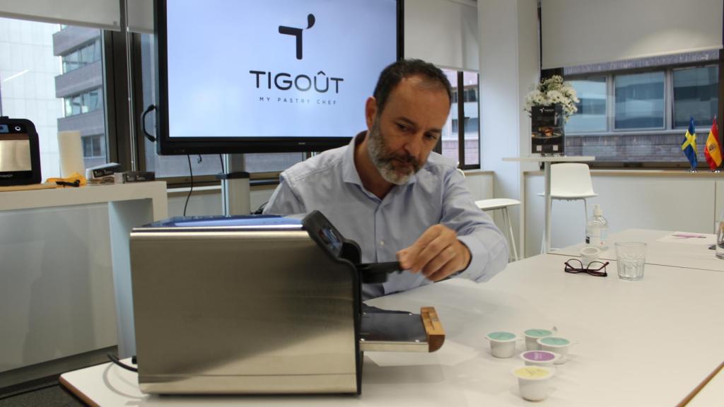 Rodrigo, tras vaciar una cápsula en un recipiente, lo introduce en el dispositivo de Tigoût para que se hornee.