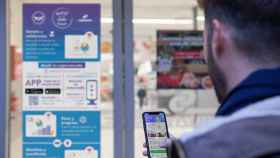 Un cliente utiliza la plataforma de la startup en la puerta en un supermercado para contribuir con su donación digital de alimentos a ayudar a los más vulnerables.