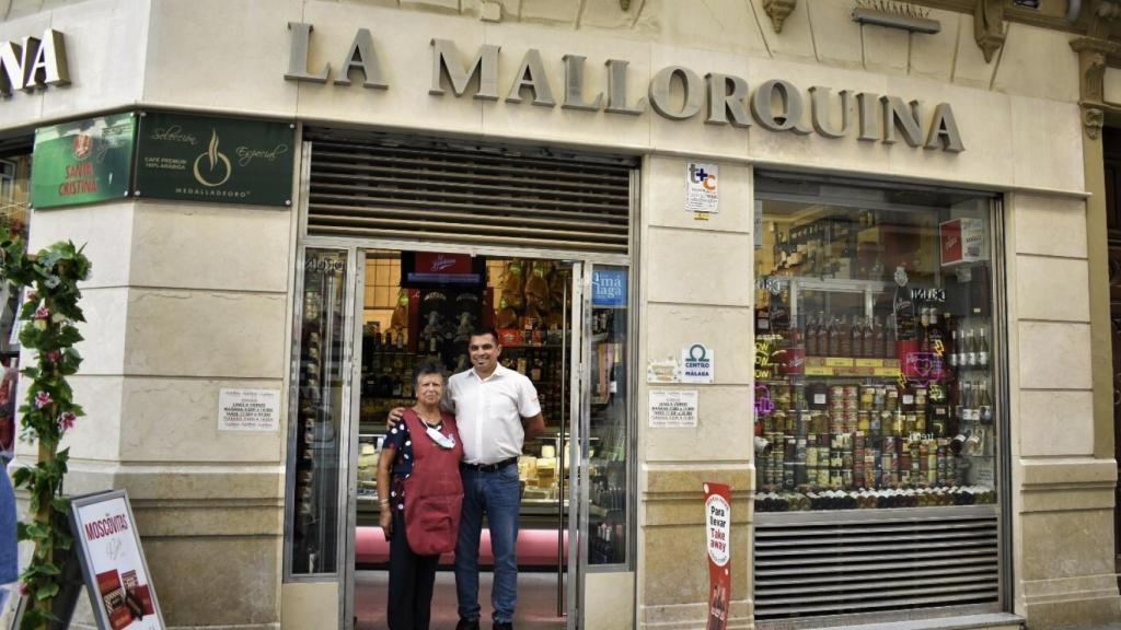 Dolores Medina Jiménez y su hijo posan frente al escaparate de La Mallorquina.