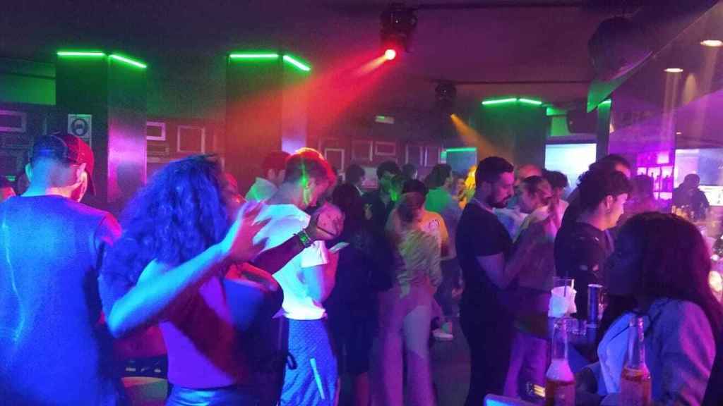 Un grupo de personas bailando en la pista de una discoteca.
