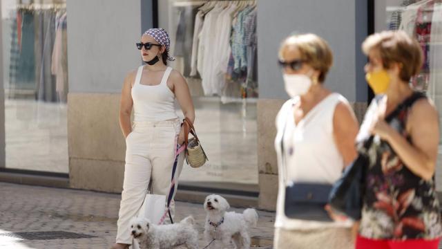 ersonas sin mascarilla y otras con mascarilla en la calle Larios.