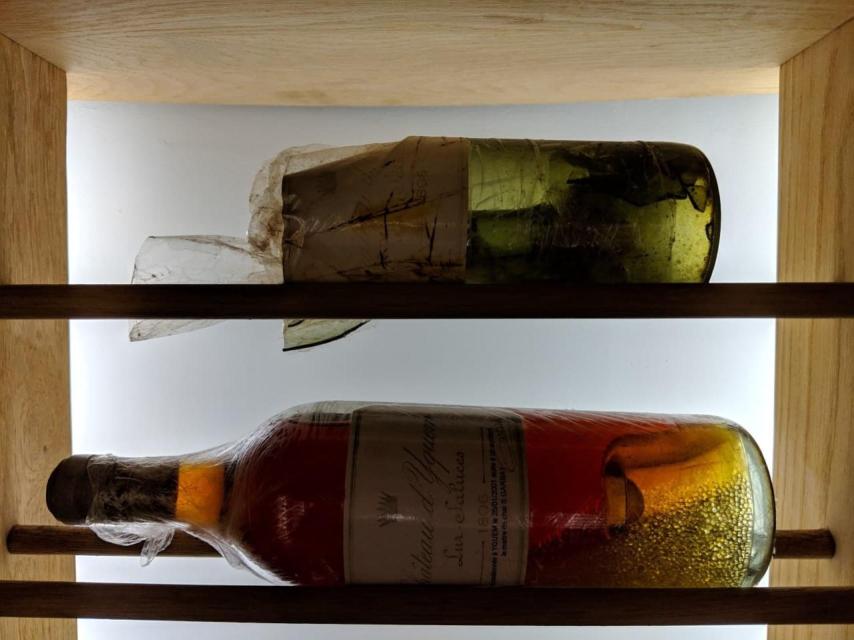 La botella original que se rompió y la botella recorchada que contiene el vino de la original