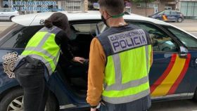 Agentes de la Policía Nacional de Sevilla meten al detenido en un coche patrulla.