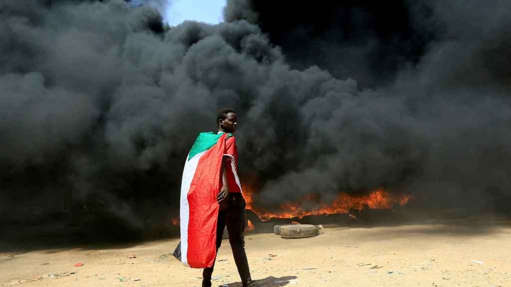 On October 21, a man took part in a demonstration holding a Sudanese flag.