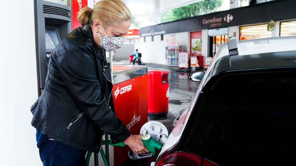 Una mujer reposta en una gasolinera tradicional.