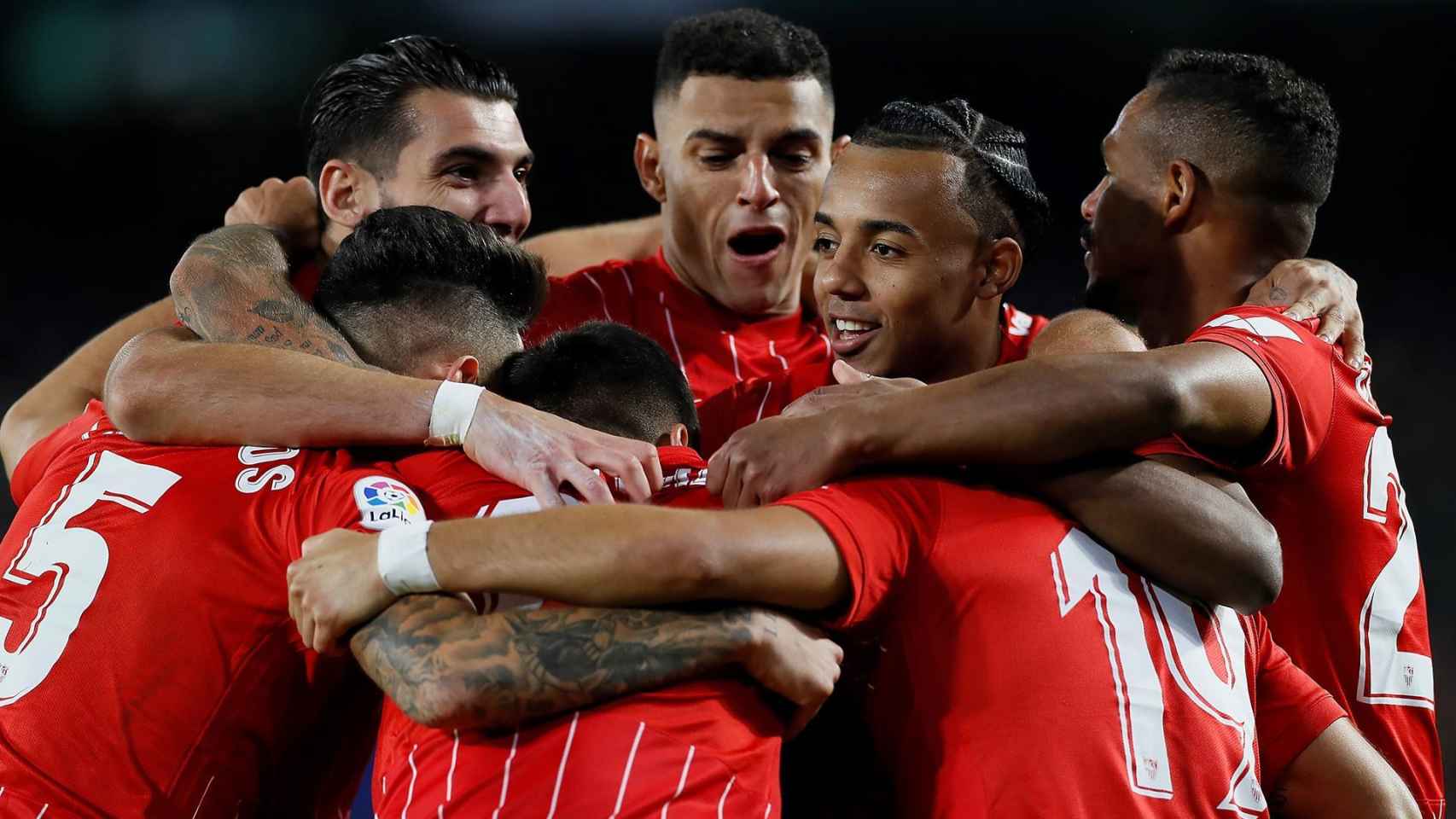 Piña de los jugadores del Sevilla para celebrar un gol en el derbi