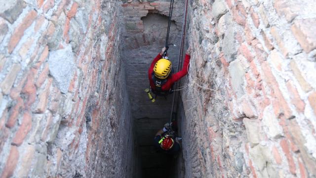 Uno de los bomberos se adentra en uno de los pozos de La Alcazaba de Málaga.