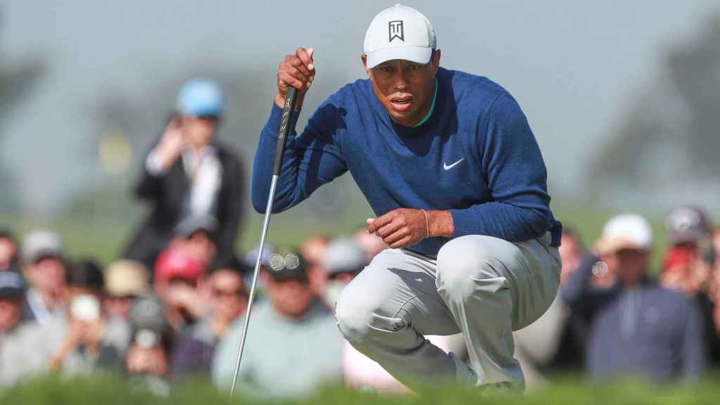 Tiger Woods observando una de sus bolas correr hacia el hoyo