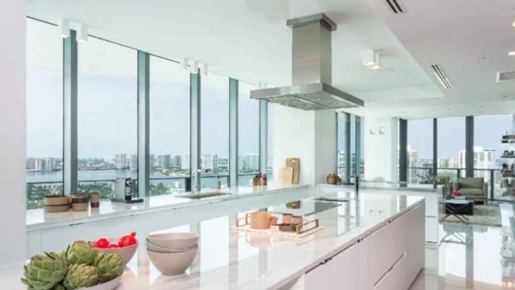 La cocina del apartamento es muy amplia, creada en blanco y acero y con un gran isla.