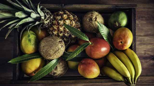 Una caja de madera con frutas tropicales.