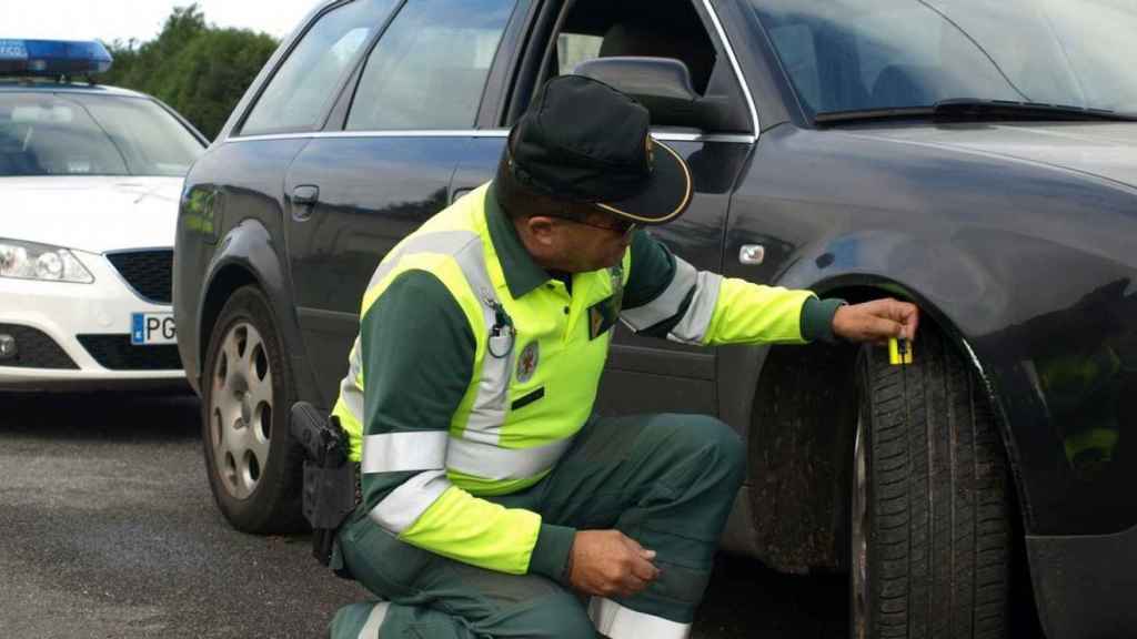 Guardia Civil de Tráfico revisando los neumáticos