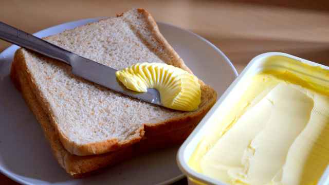 Un envase de margarina junto a una tostada.