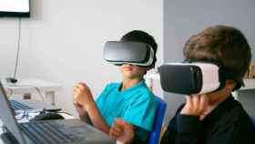 Dos niños con cascos de realidad virtual.