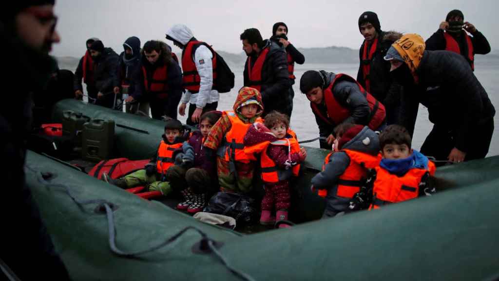 Decena de inmigrantes embarcan una embarcación inflable en la costa francesa para dirigirse al Reino Unido.