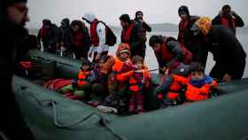 Decena de inmigrantes embarcan una embarcación inflable en la costa francesa para dirigirse al Reino Unido.