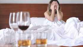 Una mujer se despierta con resaca tras beber alcohol la noche anterior.