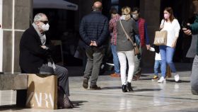 Malagueños pasean por la calle con mascarilla.