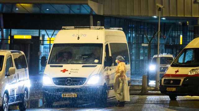 Los trabajadores sanitarios de la Cruz Roja transportan a los pasajeros infectados por el coronavirus que regresan de Sudáfrica.