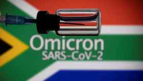 A vial and a syringe are seen in front of a displayed South Africa flag and words Omicron SARS-CoV-2 in this illustration taken