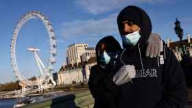 Dos ciudadanos con mascarilla pasean por el centro de Londres.