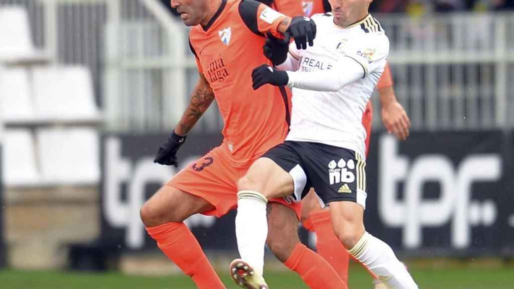 Escassi mantiene el balón ante la presión de un jugador del Burgos.