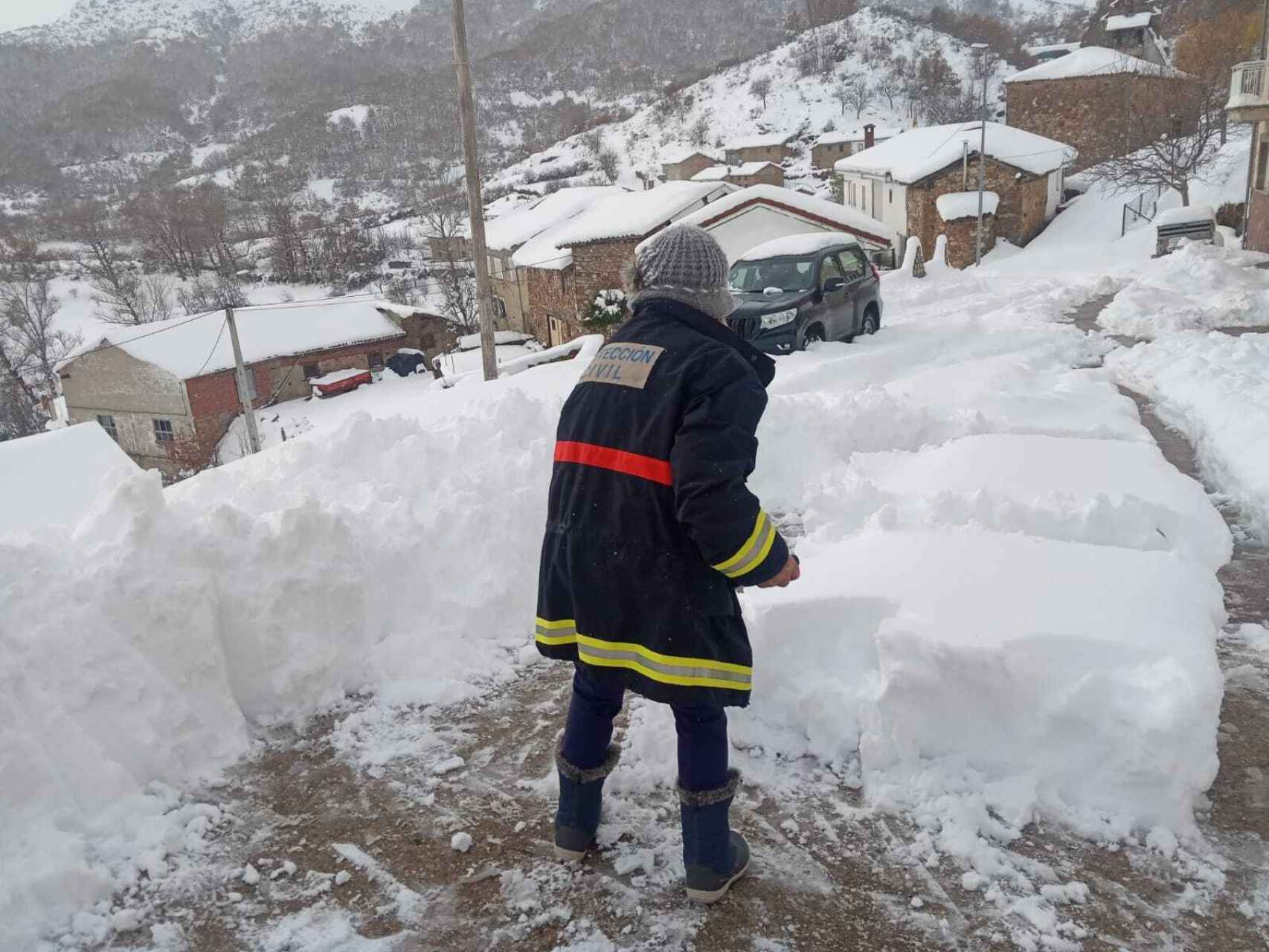 Un voluntario de Protección Civil retira la nieve para facilitar los accesos