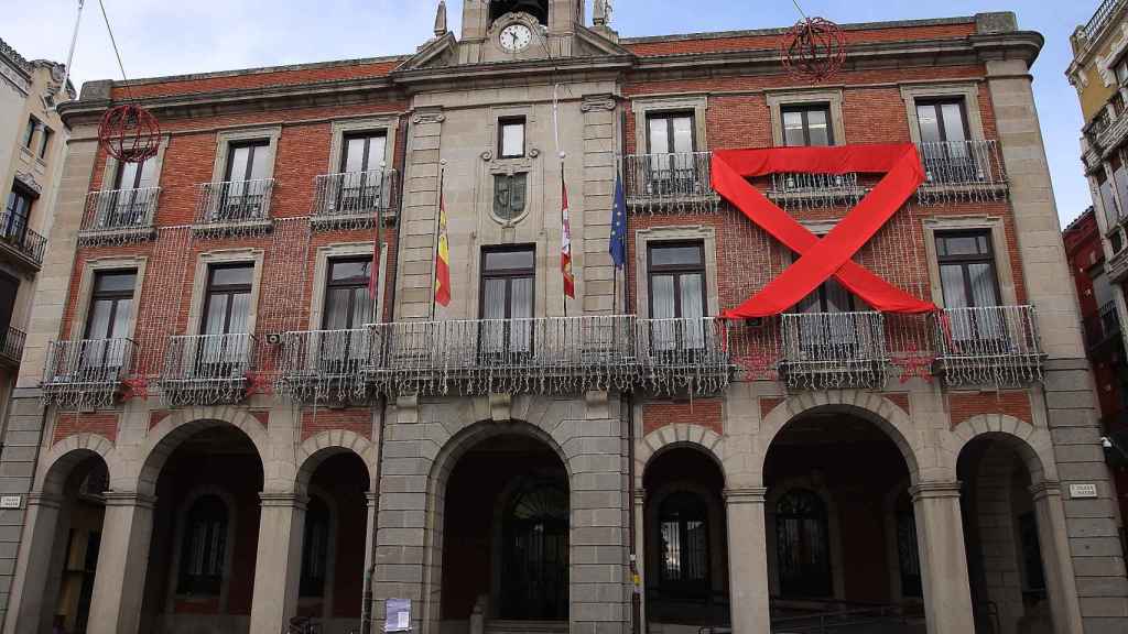 Un gran lazo rojo como símbolo de apoyo sobre la fachada del Ayuntamiento de Zamora