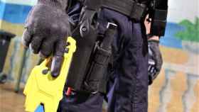 Un policía con una pistola táser en la mano.