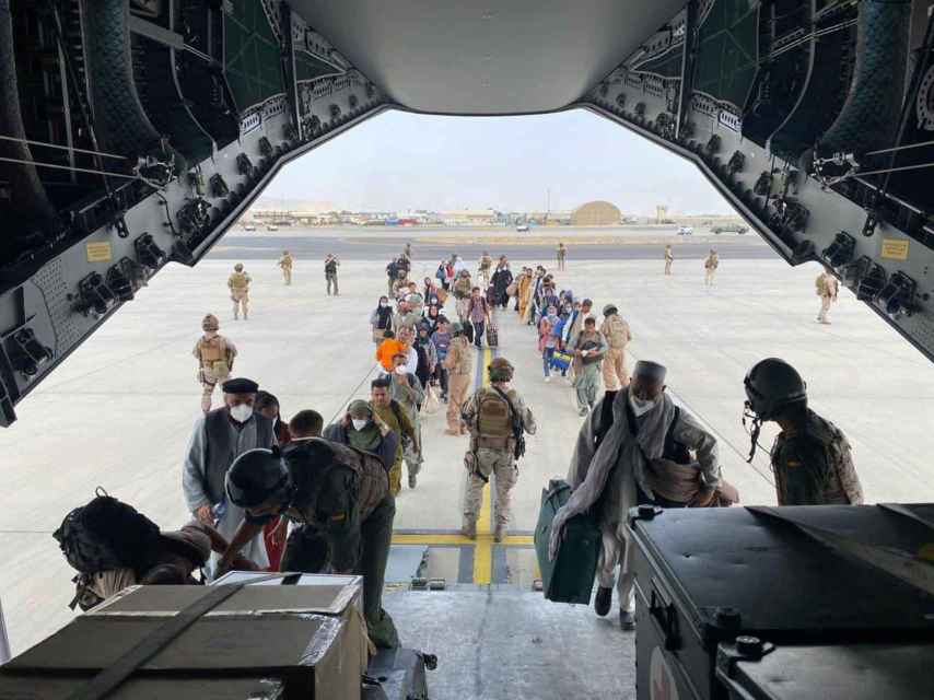 Ciudadanos afganos suben a un avión del Ejército español durante la evacuación desde el aeropuerto de Kabul.